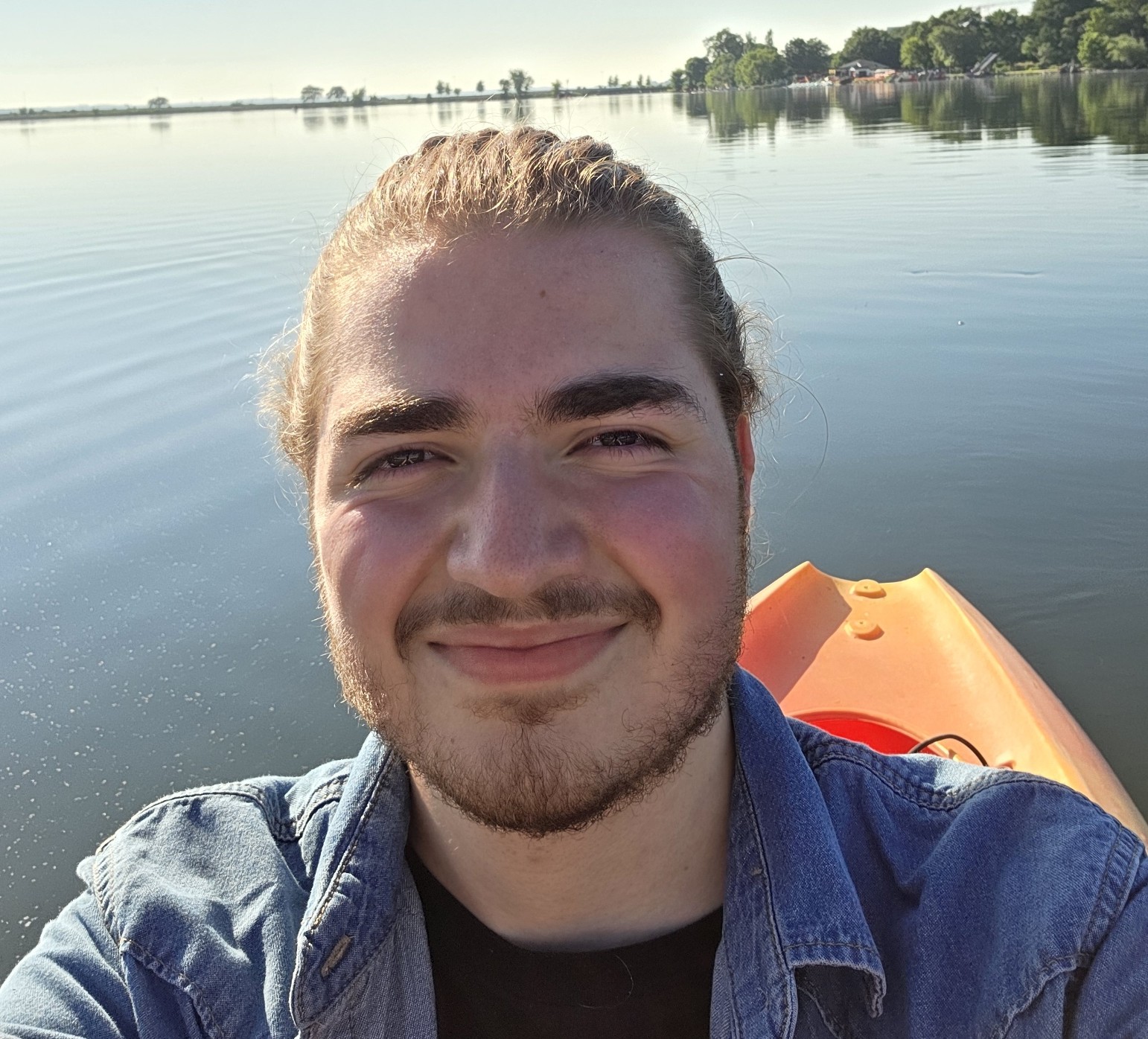 Tyson Franke smiling on a lake in a kayak